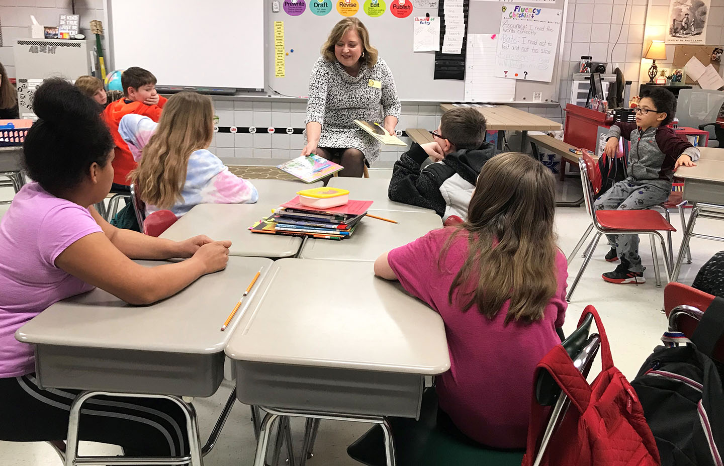 Holly Bloodworth, center, a Kentucky Board of Education member who spent 32 years teaching at Murray Elementary School, serves as a guest reader in Trina Fuller's 4th-grade class at Hickman Elementary School.