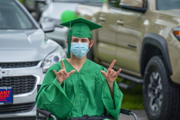 Kentucky School for the Deaf graduate Andrew Olson signs "I love you" during the school's graduation.