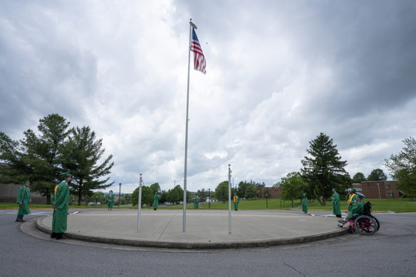 The 2020 graduating class from the Kentucky School for the Deaf gather around a flag pole during the school's non-traditional ceremony.