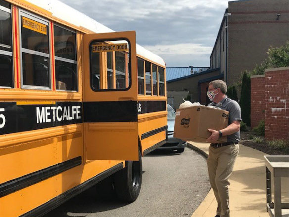 Josh Hurt loads packaged food as meals for students onto buses amid the COVID-19 pandemic.