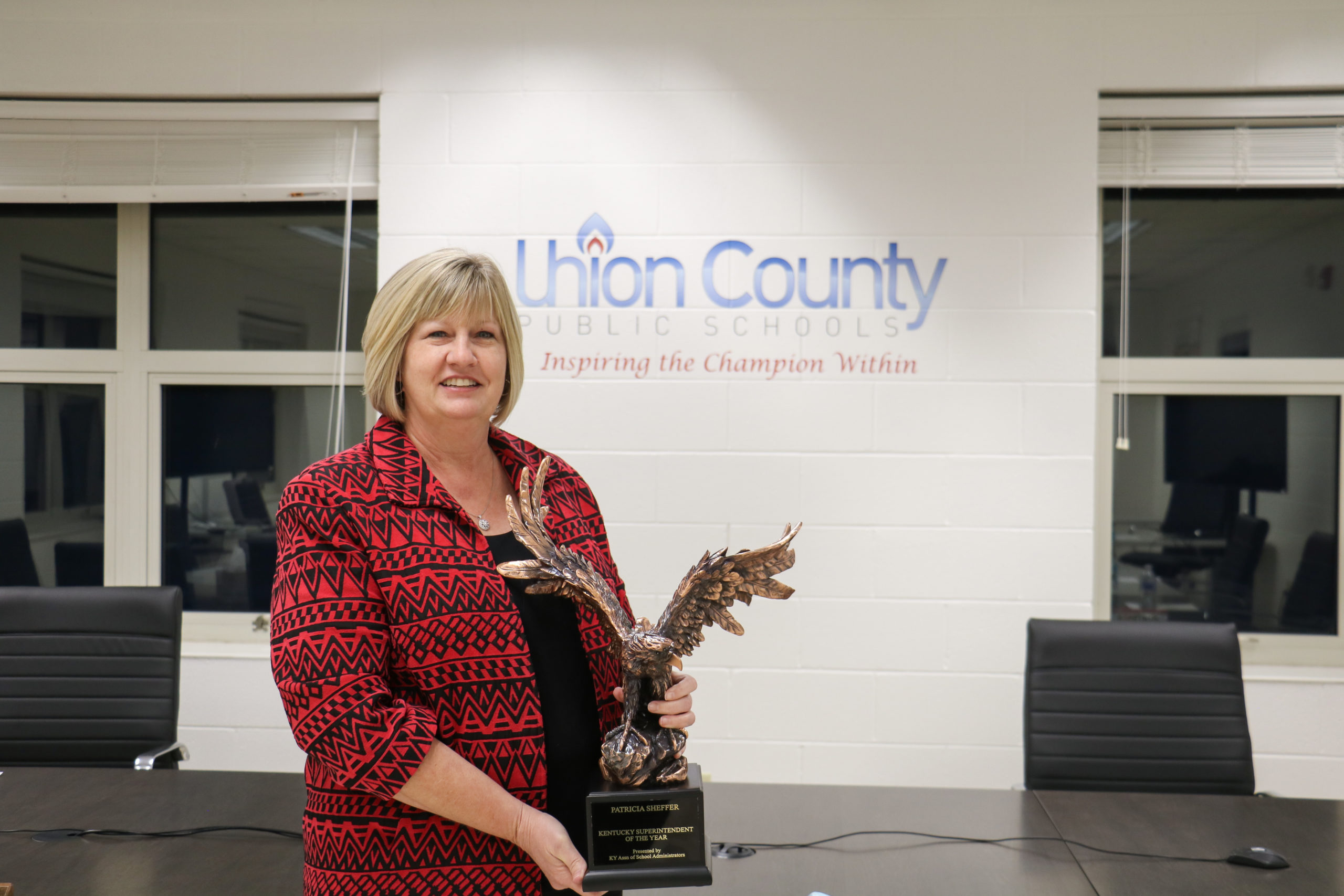 Union County Public Schools Superintendent Patricia Sheffer holds a trophy shaped like an eagle.