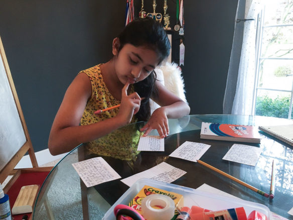 Prisha Hedau, a student at Rowe Elementary (Jefferson County), writes her daily activities on notecards.