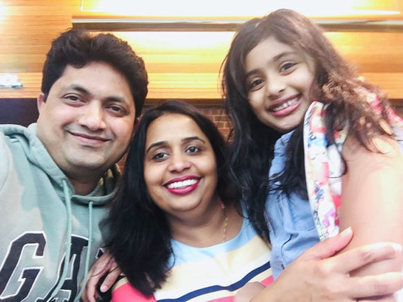 Prisha Hedau smiles with her parents Raj and Rachana.