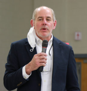 Picture of a man holding a microphone and talking.