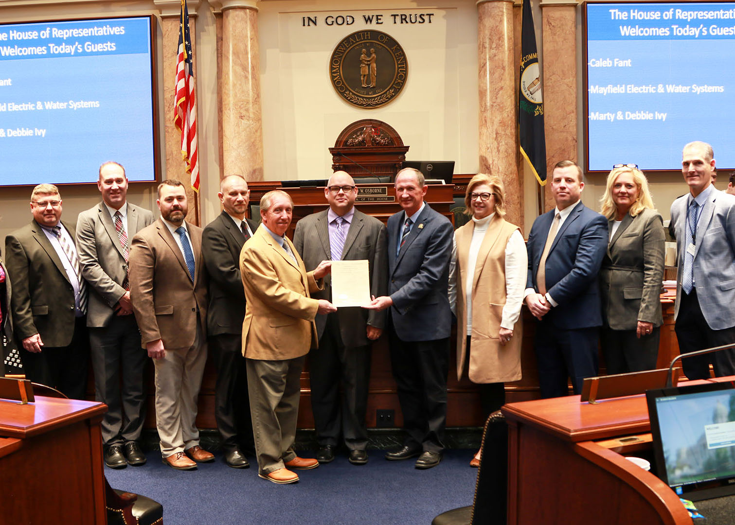 Picture of a group of people receiving a citation from a representative on the Kentucky House floor.