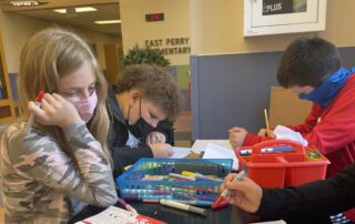 Students coloring at a table.