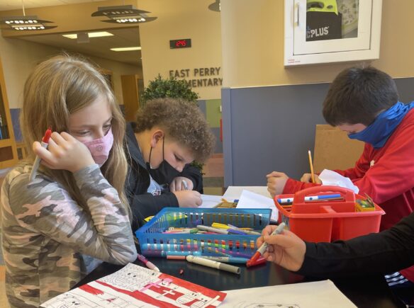 Students coloring at a table.