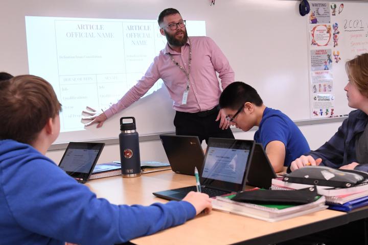 Kevin Dailey teaching his students in a classroom.