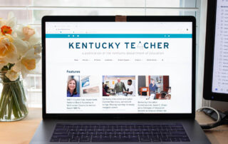 A photo of an open laptop with the Kentucky Teacher website homepage on the screen.