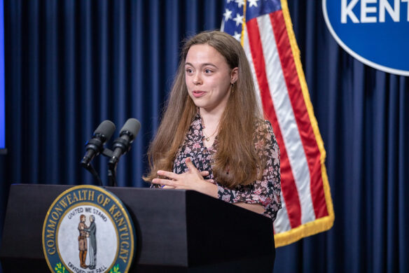 A girl speaking from behind a podium.