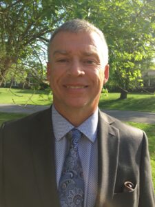 A headshot photo of a man smiling. 