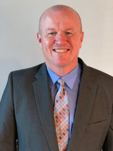 A headshot photo of a man smiling. 