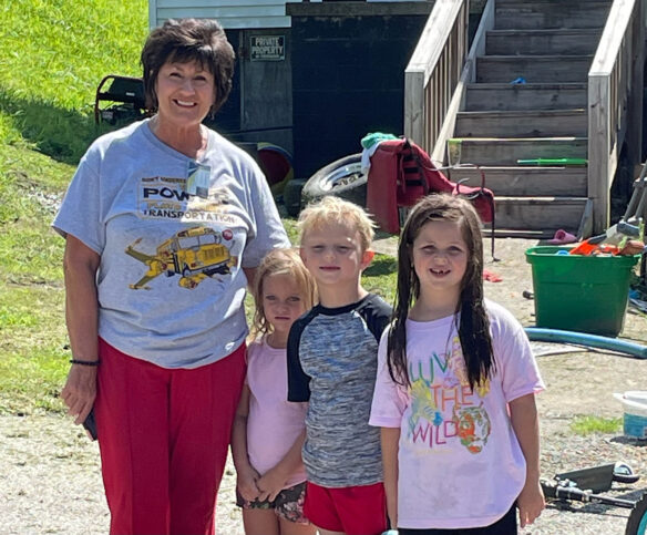 A woman stands with three children. 