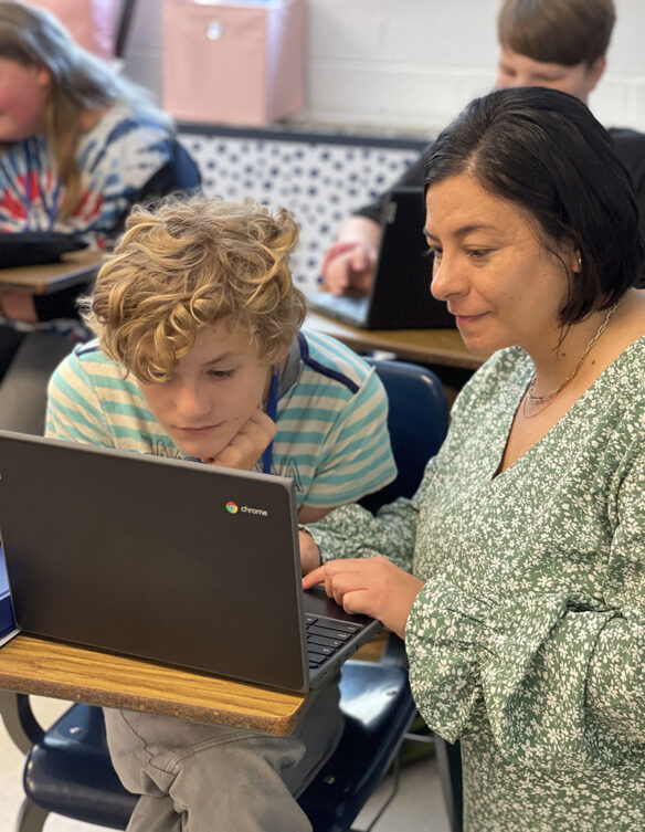 Picture of Mandy Perez working with a student in her classroom.