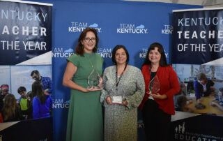 A picture of Kelly Gates, Mandy Perez and Amber Sergent holding glass trophies.