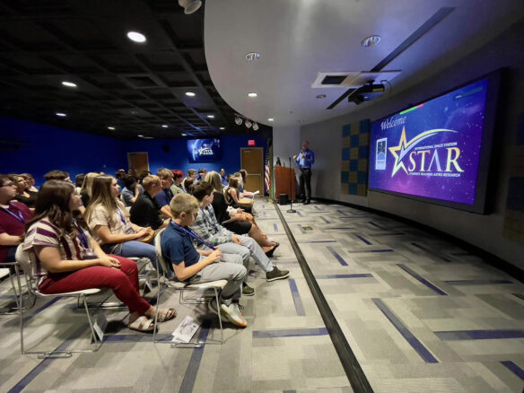 A crowd sitting in chairs watches a presentation at the Challenger Learning Center of Kentucky. 