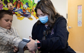 A school nurse checks a student's vitals.