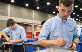 Picture of two students working on electrical wiring projects as part of the SkillsUSA contest.