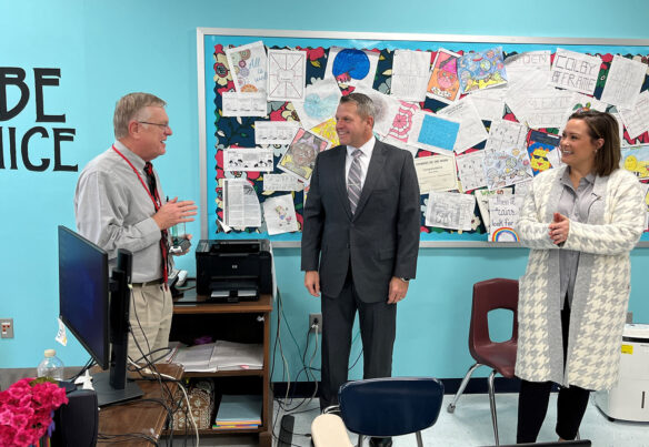 A picture of Michael Wright smiling and talking to Jason E. Glass and Jacqueline Coleman while standing in a classroom.