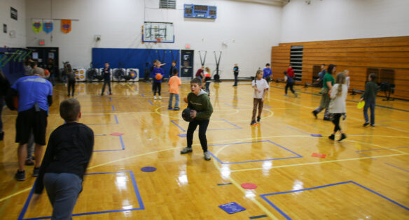 Several students play in a gym. 