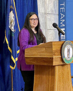 A picture of Gretta Hylton speaking at a podium.