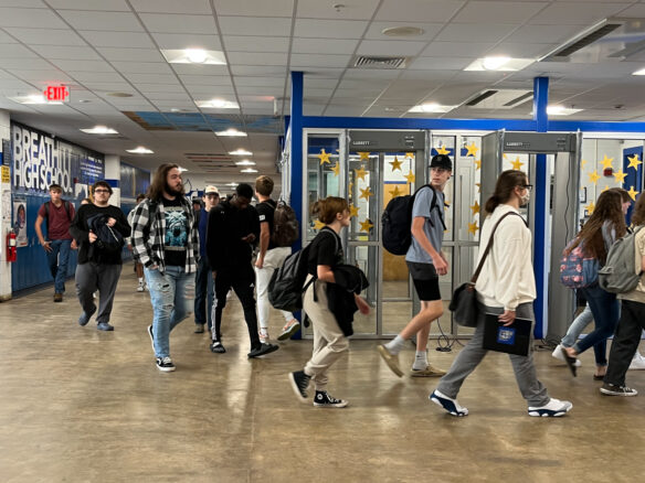 Several students walk through the halls of a school