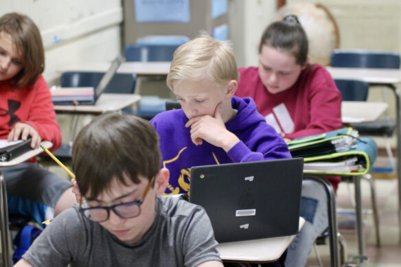 Students sit at desks in a classroom