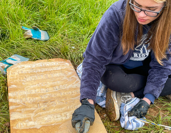 A girl cleans off a headstone