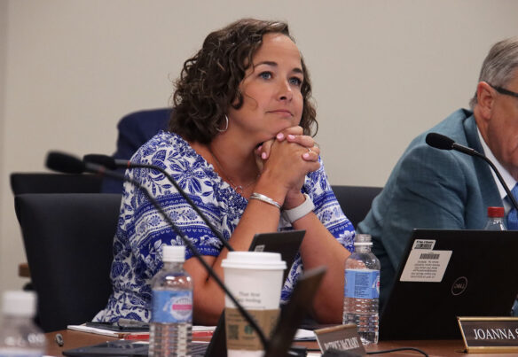 Picture of Joanna Stevens, sitting at a conference table with her head resting on her hands.