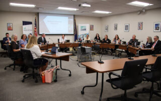 Picture of the members of the Kentucky Board of Education sitting around conference tables and talking.