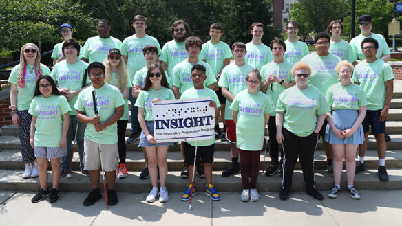 Picture of a large group of students standing on steps holding a sign reading Insight, Postsecondary Preparation Program.