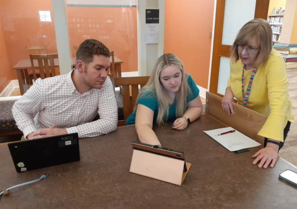 Picture of Breanna Williams sitting at a table with Hunter Consley and Betsy Tweedy, working on a computer.