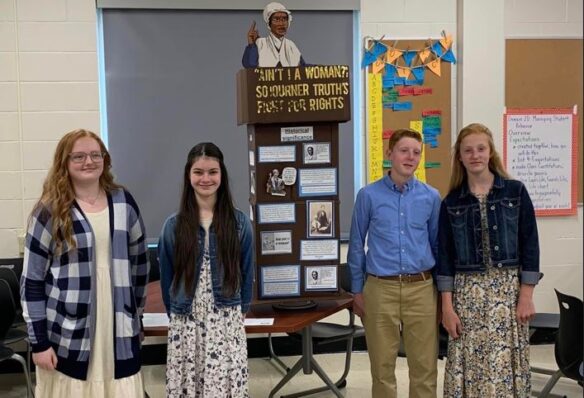 Rayawna Holland, Rylee Fuson, Sawyer Frye and Savannah Frye stand in front of their history project.