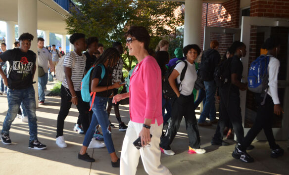 Hardin County Superintendent, Teresa Morgan walking outside of the school surrounded by students walking into the school building.