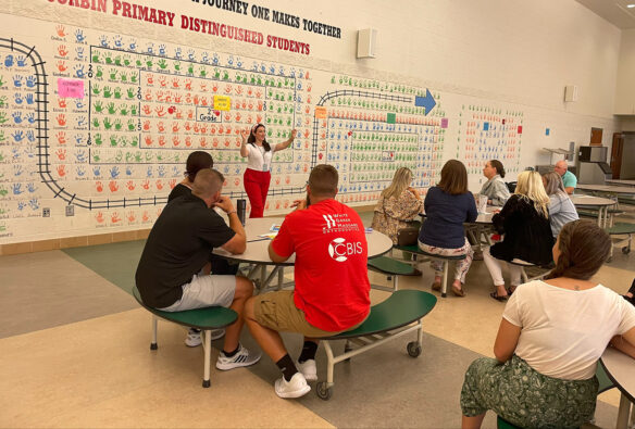 Ashley Hill stands in front of a room full of kids