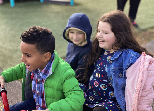 Three kids sit on a playground