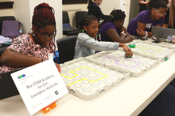 Three students showcasing their robots at Coding at the Capitol