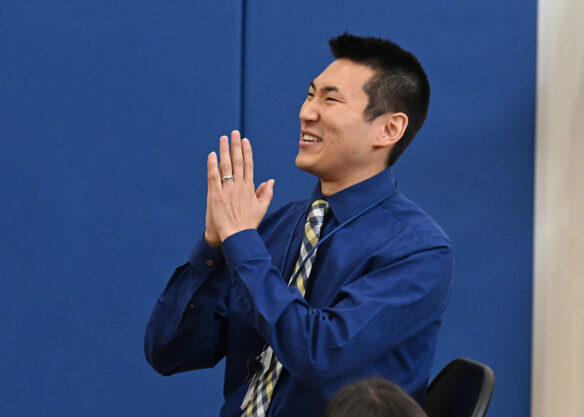 Shane Baker smiles and claps his hands in surprise.