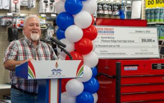 Photo of David McCoy speaking at a podium in a hardware store