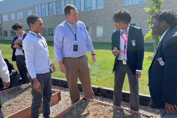 Jacob Ball stands outside with a few students