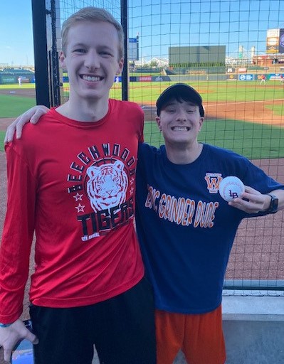 Photo of older student and younger student at a baseball field