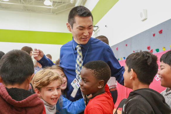 Shane Baker is surrounded by children after finding out he won an award