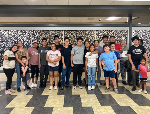 A group of students and family members pose for a photo