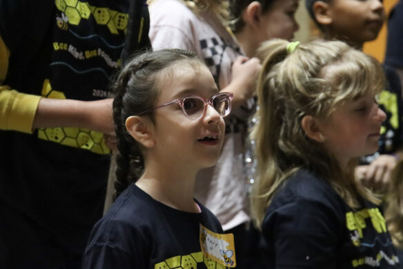 A girl with glasses looks off into the distance