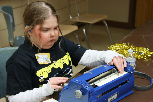 MaKenna Harrod practices on a braille machine