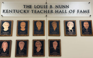 Plaques with faces engraved on them sit on a wall under the words "The Louis B. Nunn Kentucky Teacher Hall of Fame"