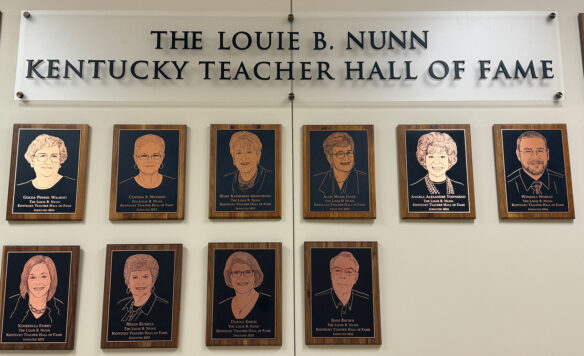 Plaques with faces engraved on them sit on a wall under the words "The Louis B. Nunn Kentucky Teacher Hall of Fame"