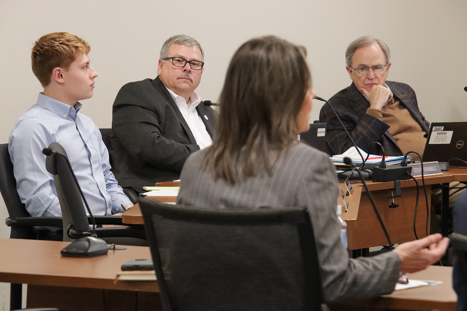 Three Kentucky School Board members listen to Jennifer Stafford present at the board's meeting on March 26.