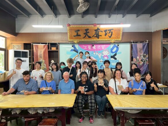 A group of people pose for a photo inside a classroom in Asia
