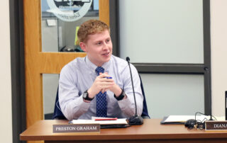 Preston Graham sitting at a table during a Kentucky Board of Education meeting.